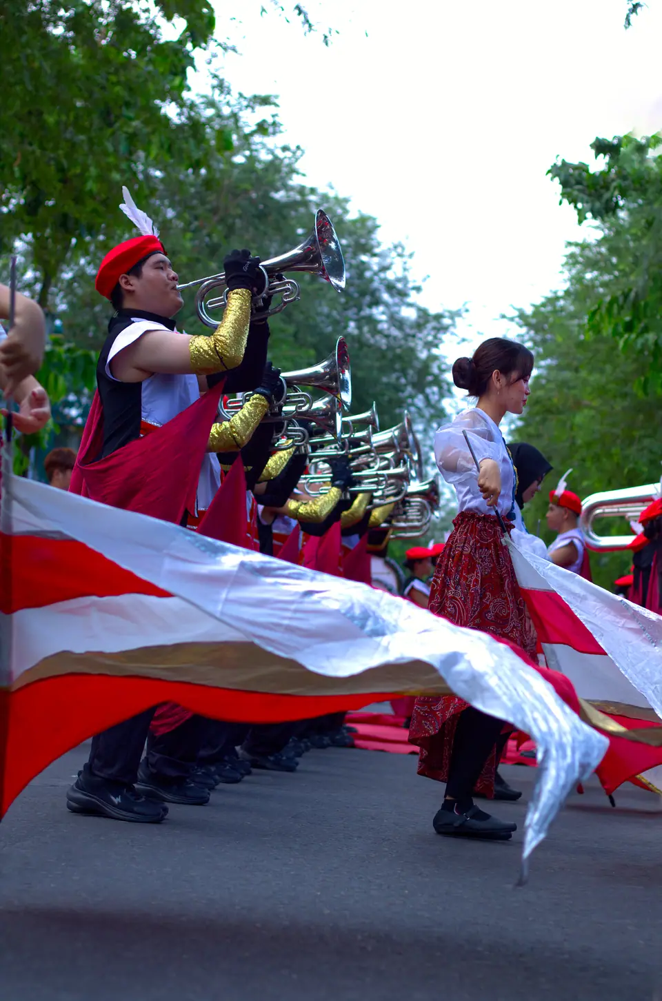 Dokumentasi parade marching band dengan bendera merah putih berkibar, foto oleh Al
