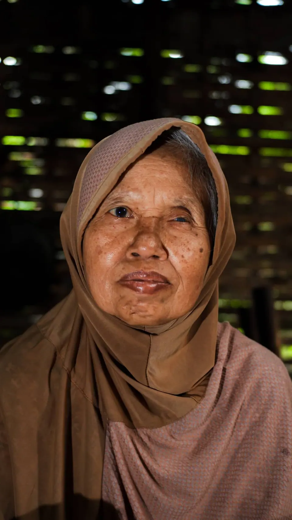 Portrait karakter seorang nenek berkerudung dengan cahaya lembut dari samping, foto oleh Doeng