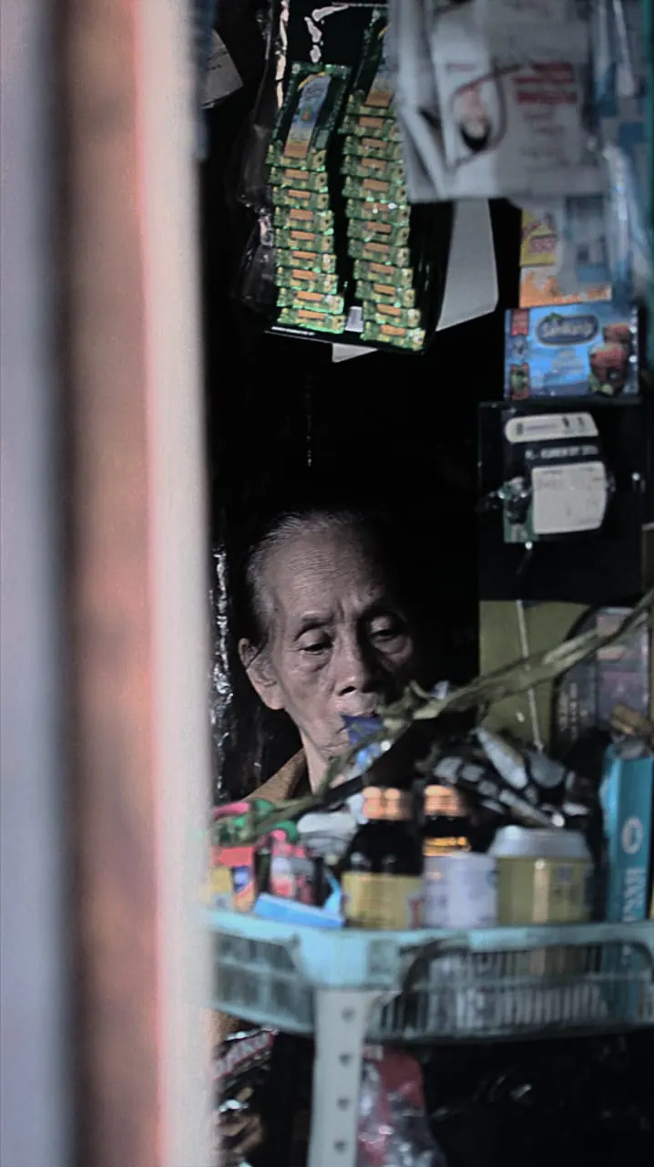 Foto dokumenter pemilik warung lansia di balik barang dagangan, foto oleh Felix