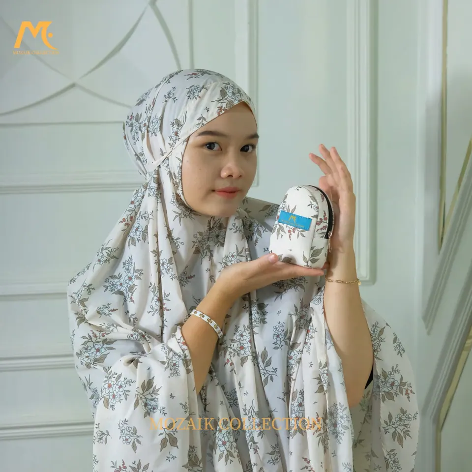 Foto produk fashion: model berhijab memegang tas kecil di studio bernuansa putih, foto oleh Hilenss