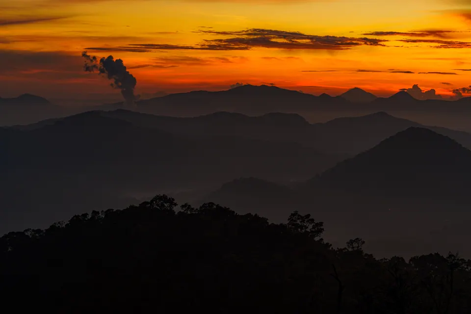 Foto lanskap siluet pegunungan saat langit jingga matahari terbit, foto oleh Igoruigori