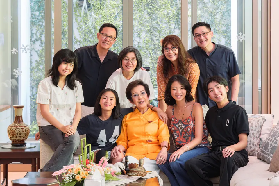 Foto keluarga besar tiga generasi di ruang tamu yang terang, foto oleh Igoruigori
