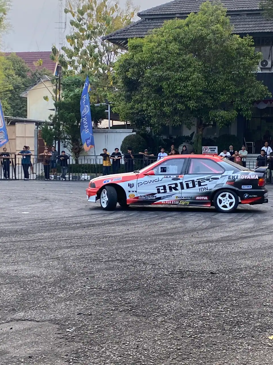Dokumentasi event otomotif: mobil drift melaju di depan penonton, foto oleh Mario