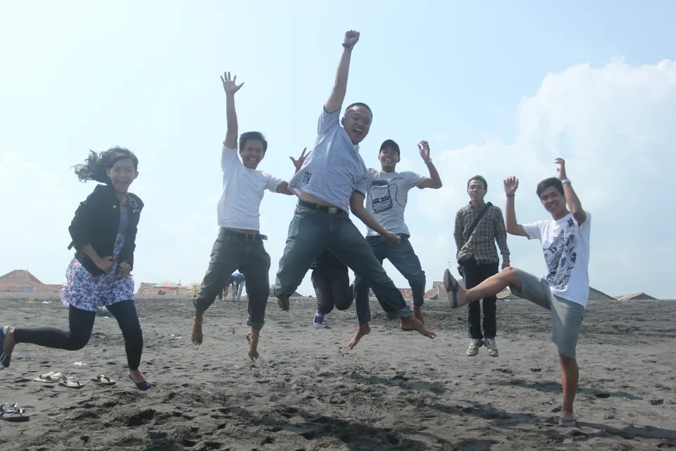 Foto grup: rombongan melompat bersama di pantai pasir hitam, foto oleh PapperSpray