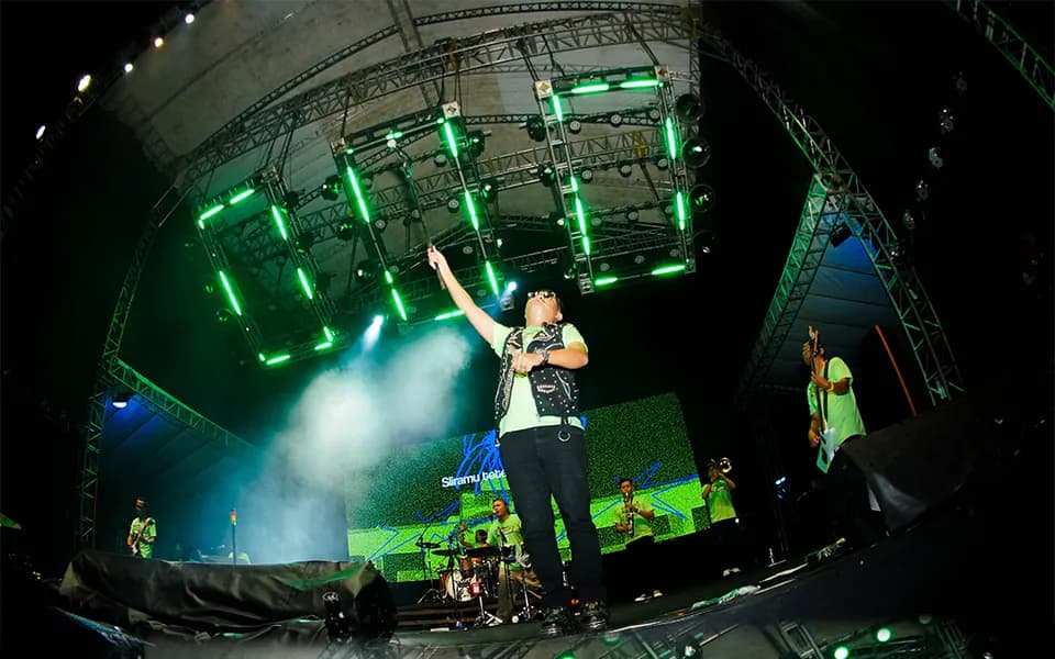 Foto konser: vokalis di atas panggung dengan rangka lampu hijau, foto oleh Rifqi
