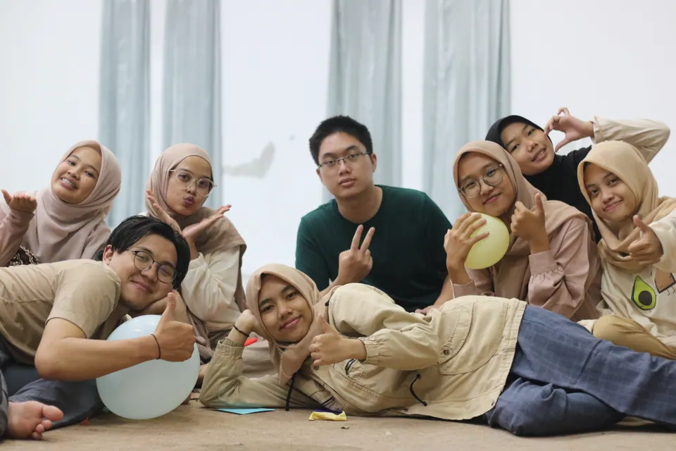 Foto grup kreatif: sekelompok teman berpose santai di lantai studio, foto oleh Sigma Photo